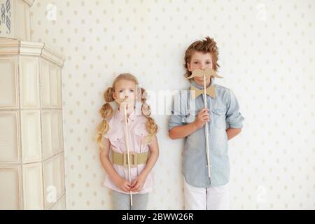 Portrait von Jungen und Mädchen halten Pappbart und Lippen Stockfoto