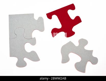 Puzzleteile grau, teilweise in rot, Konzept, Symbolhintergrund isoliert Stockfoto