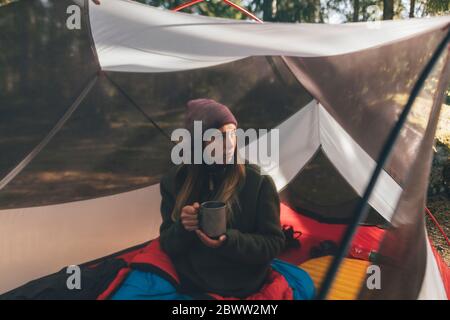 Junge Frau im Zelt ist der Wald, Tee trinken Stockfoto