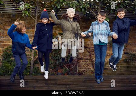 Gruppe von Kindern, die in der Pause auf dem Schulhof springen Stockfoto
