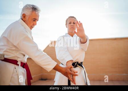 Frau mit Lehrer während Karate-Training auf der Terrasse Stockfoto