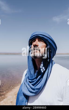 Mann in der Wüste von Merzouga vor dem See, Marokko Stockfoto