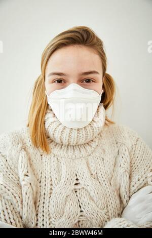 Portrait der blonden Frau trägt FFP2 Maske zu Hause Stockfoto