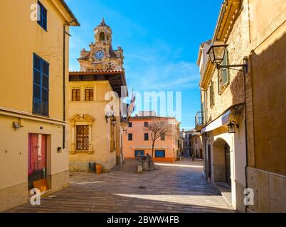 Spanien, Balearen, Mallorca, Alcudia, Altstadtstraße mit Rathausturm im Hintergrund Stockfoto