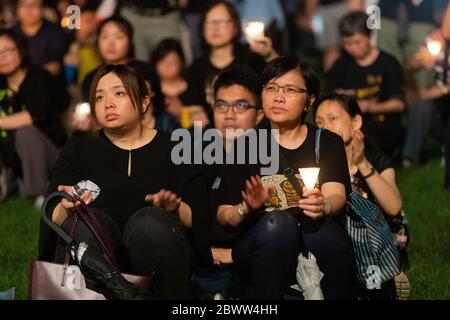 Teilnehmer der Tiananmen-Platz-Mahnwache in Hongkong, die Reden lauscht, während sie Kerzen im Victoria Park, Hongkong, am 4. Juni 2019 halten Stockfoto