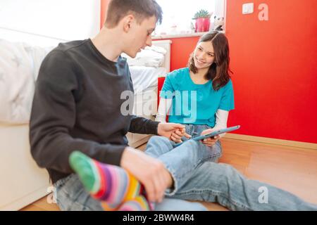 Portrait von lächelndem Teenager-Mädchen lernen zusammen mit ihrem Freund zu Hause Stockfoto