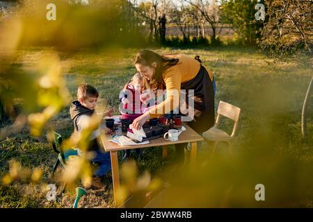 Mutter mit zwei Kindern im Garten Stockfoto