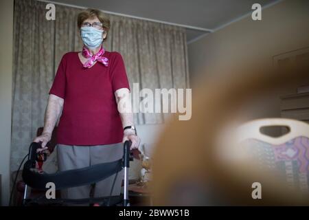 Ältere Frau mit Wanderhilfe auf Rädern in ihrer Wohnung, Altersheim Stockfoto