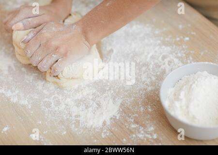 Nahaufnahme der weiblichen Hände, die einen Teig für Kuchen auf dem Tisch machen Stockfoto