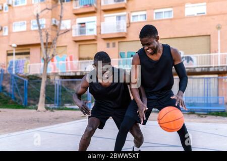 Basketballspieler spielen Basketball auf dem Platz im Freien Stockfoto