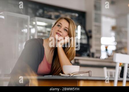 Porträt einer träumenden jungen Frau in einem Café Stockfoto