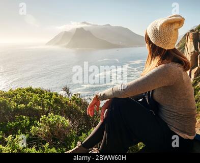 Frau, die die Aussicht von der Spitze eines Berges genießt, Chapman's Peak Drive, Südafrika Stockfoto