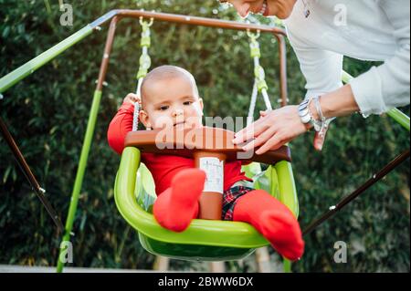 Portrait des Jungen auf Schaukel im Garten sitzen Stockfoto