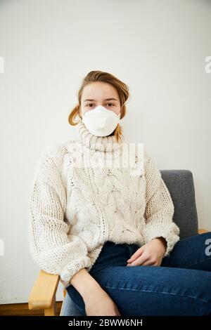 Portrait der blonden Frau trägt FFP2 Maske zu Hause Stockfoto