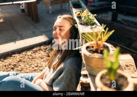 Junge Frau genießt die Sonne im Garten Stockfoto