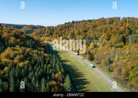 Deutschland, Baden-Württemberg, Heidenheim an der Brenz, Drohne Blick auf den Verkehr auf der Autobahn entlang des Herbstwaldes Stockfoto