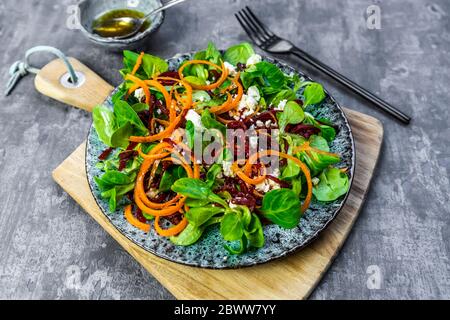 Teller vegetarischer Maissalat mit Feta-Käse, Karottenstreifen und Rote Beete Streifen Stockfoto