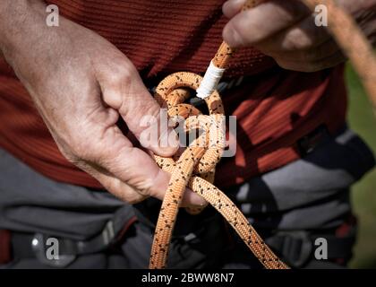 Eine Acht an einen Klettergurt binden Stockfoto