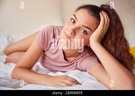 Porträt der jungen Frau auf Bett Stockfoto
