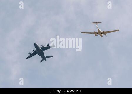 Royal Air Force Airbus A400M Atlas Transportflugzeug, das über einem Diamond Flugzeug DA42 Twin Star auf separaten Flugebenen fliegt. Kontrollierter Luftraum Stockfoto