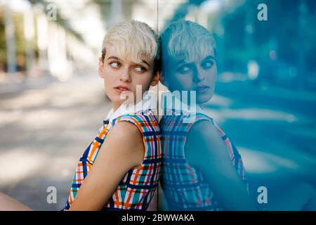 Portrait von weiblichen Teenager tragen bunte Kleid in Glasscheibe gespiegelt Stockfoto