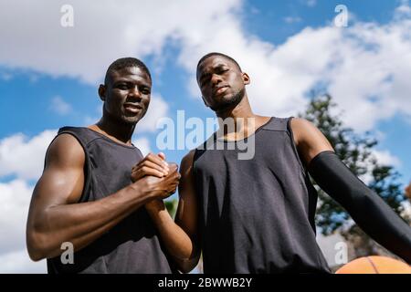 Basketballspieler Handshaking auf Outdoor-Basketballplatz Stockfoto