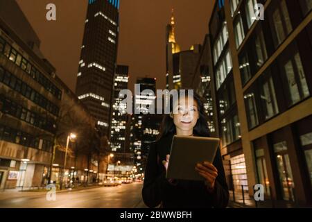 Porträt einer jungen Frau in der Stadt bei Nacht, Frankfurt, Deutschland Stockfoto