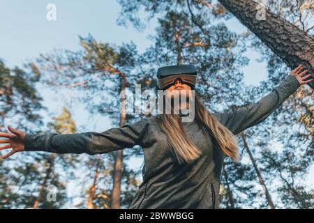 Junge Frau mit VR-Brille in der Natur Stockfoto