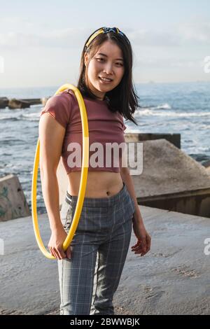 Glückliche Frau mit Hula Hoop Reifen am Hafen Stockfoto