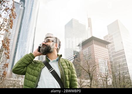 Mann am Telefon vor den Skycrapers, Frankfurt, Deutschland Stockfoto