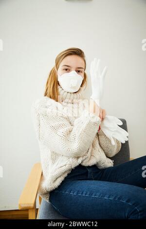 Portrait der blonden Frau trägt FFP2 Maske zu Hause Stockfoto