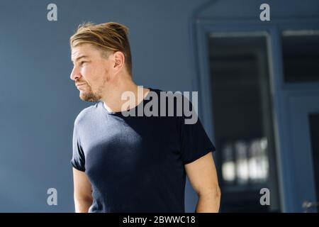 Bärtiger Mann mit T-Shirt und wegblickender Blick Stockfoto