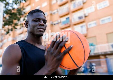 Porträt des jungen Mannes hält basketball Stockfoto
