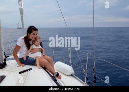 Mutter und ihre Tochter sitzen auf dem Bootsdeck während des Segeltörns Stockfoto