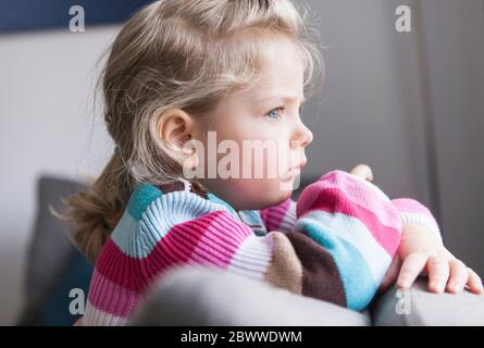 Portrait des Mädchens, das aus dem Fenster schaut Stockfoto