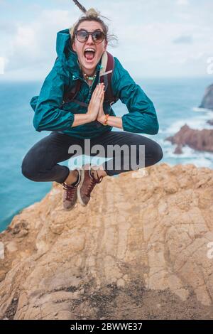 Portugal, Lissabon, Sintra, Portrait einer Wanderin, die am Rande der Klippe Cabo da Roca springt Stockfoto