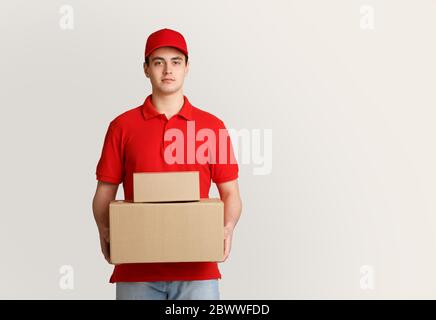 Kuriersitzung. Der Überlieferer hält Pakete in seinen Händen Stockfoto