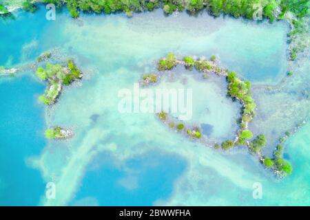 Romantische Küste mit grüner Vegetation und türkisblauem Wasser oben aus der Luft Stockfoto