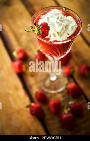 Cocktail mit frischen Erdbeeren auf einem alten rustikalen Tisch Stockfoto