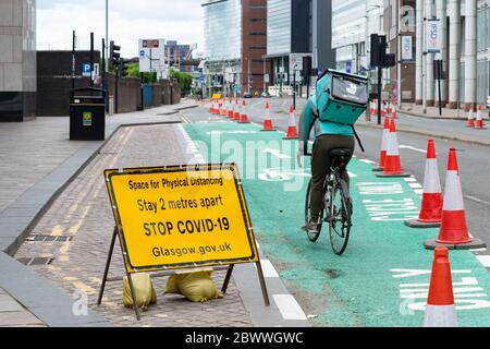 Glasgow, Schottland, Großbritannien. 3. Juni 2020. Radfahrer in Glasgow nutzen am World Bicycle Day 2020 ruhige Straßen und bestehende und neue Radwege (hier gezeigt temporärer Radweg entlang der Broomielaw). Quelle: Kay Roxby/Alamy Live News Stockfoto