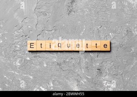 ETIKETTE Wort auf Holzblock geschrieben. ETIKETTE Text auf Zementtisch für Ihr Design, Konzept. Stockfoto