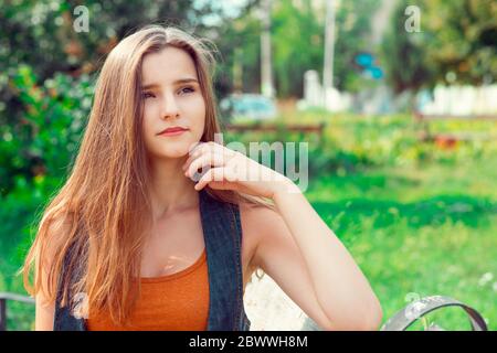 Frauen denken. Nahaufnahme Porträt Kopfschuss Gesicht schön zuversichtlich ernst nachdenklich junge Dame Mädchen Finger auf dem Kinn isoliert grünen Park im Freien backg Stockfoto