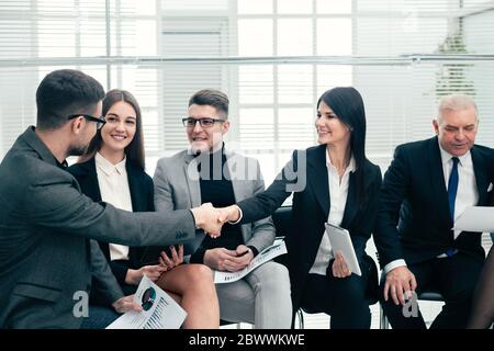 Im Konferenzraum grüßen sich Geschäftskollegen gegenseitig. Stockfoto