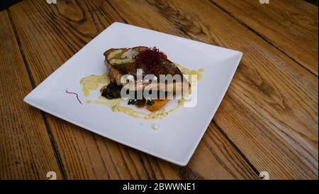 Köstliches gebratenes Lachsfilet, Gewürze auf blauem rustikalem Betontisch. Gekochtes Lachssteak mit Pfeffer, Kräutern, Zitrone, Knoblauch, Olivenöl, Löffel. Stockfoto