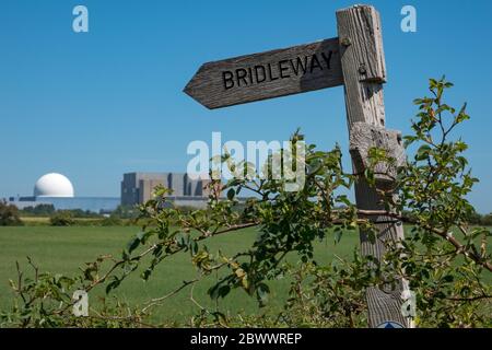 Kernkraftwerk Sizewell A und B in einem Hintergrund mit weichem Fokus und einem hölzernen 'Brückenweg' und 'Fußweg' Schild im scharfen Fokus Vordergrund Stockfoto