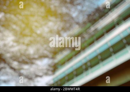 Verschwommene Ansicht von unten des Gebäudes mit Baum und Licht Leck. Stockfoto