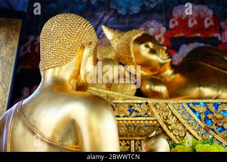 Nahaufnahme der Statue des goldenen Schüler mit dem uralten Bild des sich wieder schließendem Buddha. Stockfoto