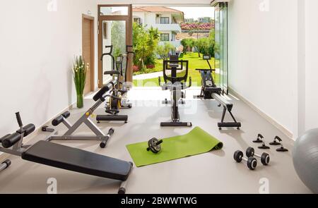 Modernes Konzept der grünen Natur Öko-Stil Fitnessraum. Vorderansicht des stilvollen Schulungsraums Interieur in Hotel, Wohnung, Haus mit Open-Air-Gartenfenster Stockfoto