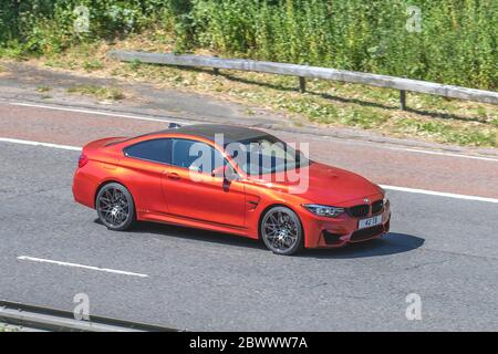 2019 orange BMW M4 Competition Package S-; Fahrzeug Verkehr bewegende Fahrzeuge, Autos fahren Fahrzeug auf UK Straßen, Motoren, Autofahren auf der Autobahn M6 Autobahn Stockfoto