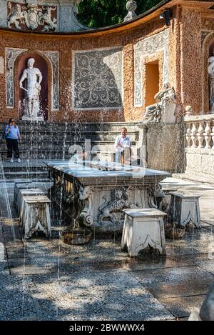 In einem Esstisch versteckte Trick-Brunnen und Skulpturen am Teich im Öffentlichen Garten des Schlosses Hellbrunn in Salzburg Stockfoto